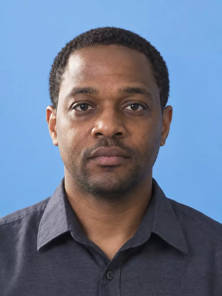 Synthetic portrait after editing, with the same subject's glasses removed and facial lighting balanced